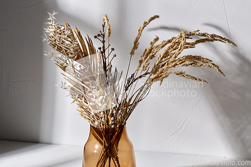 Image of decorative dried flowers in brown glass vase