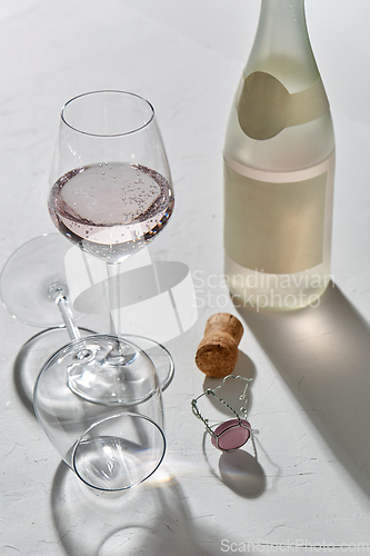 Image of wine glasses and champagne bottle dropping shadows