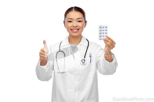 Image of asian female doctor with pills showing thumbs up