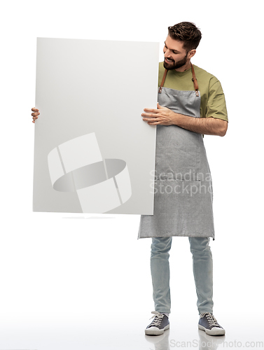 Image of happy barman in apron holding empty white board