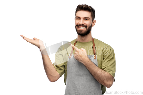 Image of happy barman in apron holding something imaginary