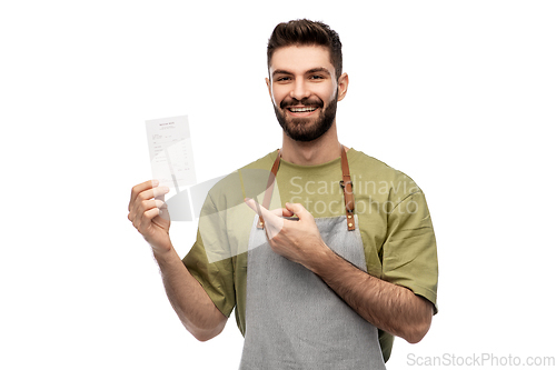 Image of happy smiling barman in apron with bill