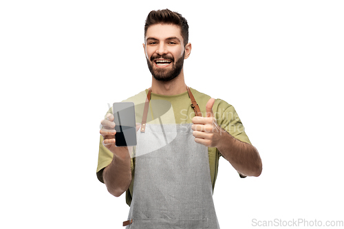 Image of happy barman showing smartphone and thumbs up