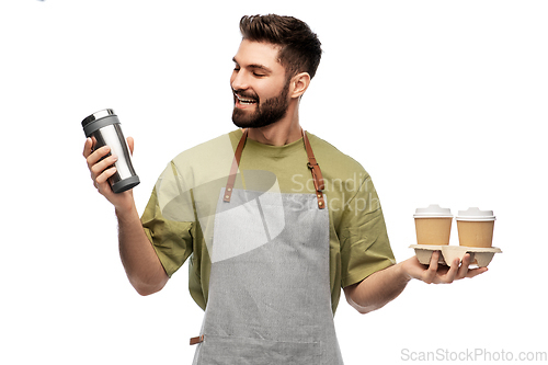 Image of happy waiter with takeout coffee cups and tumbler