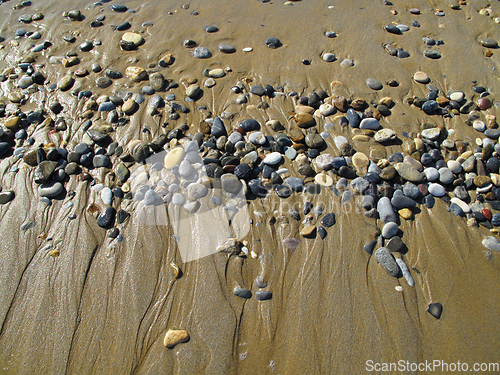 Image of Wet sea pebbles on the sand