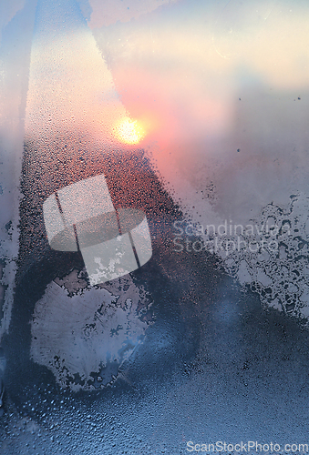 Image of Ice pattern and water drops on glass on a sunny winter morning