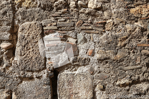 Image of Texture of an old wall of stones and bricks lit by sunlight