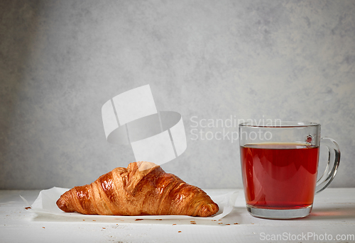 Image of close up of tea cup and croissant