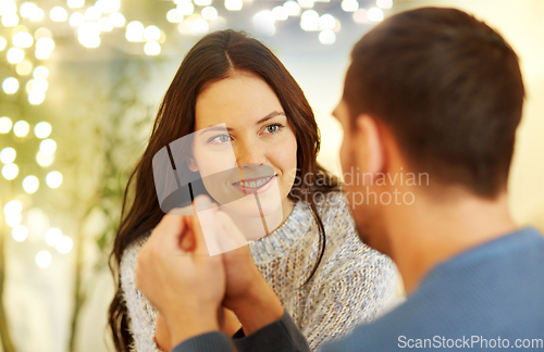 Image of happy couple holding hands at restaurant or cafe