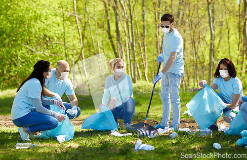 Image of volunteers in masks with cleaning garbage at park