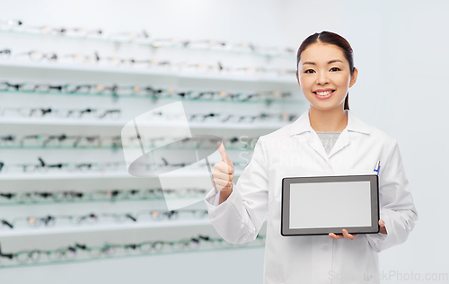 Image of asian female doctor with tablet pc shows thumbs up