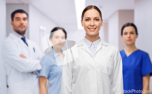 Image of smiling female doctor with colleagues at hospital