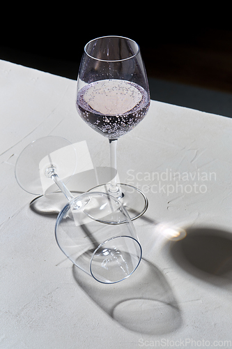 Image of wine glasses dropping shadows on white surface