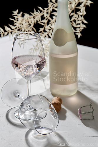 Image of wine glasses and champagne bottle dropping shadows