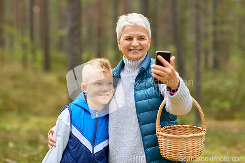 Image of grandmother and grandson with baskets take selfie