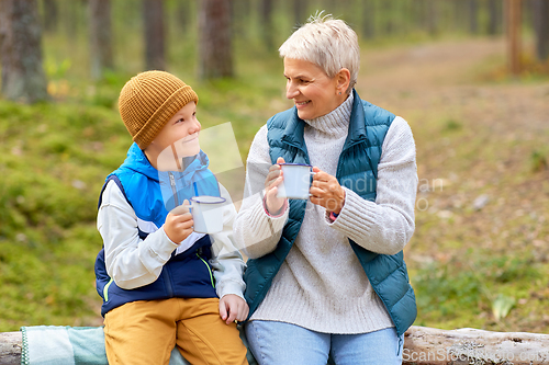 Image of grandmother with grandson drinking tea in forest