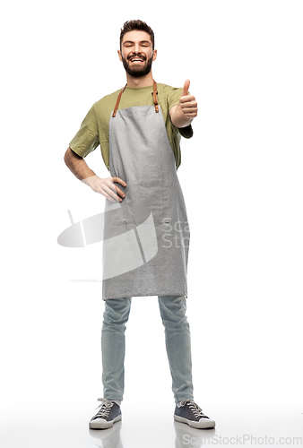 Image of happy smiling barman in apron showing thumbs up