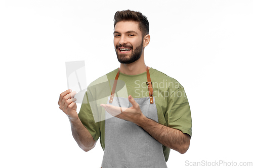 Image of happy smiling barman in apron with bill