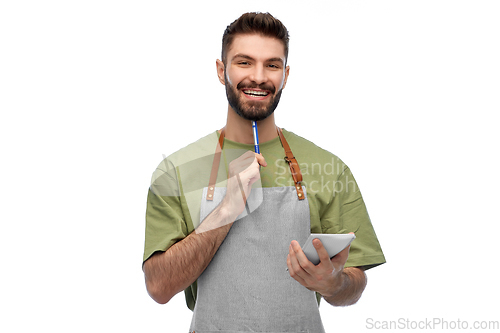 Image of smiling waiter in apron with pen and notepad