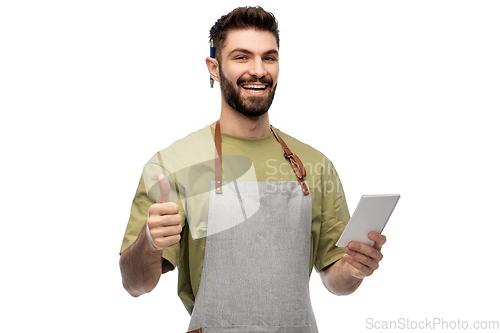 Image of smiling waiter in apron taking notes to notepad