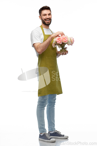 Image of happy smiling male gardener with flowers in vase