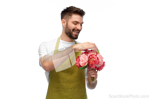 Image of smiling male gardener with bunch of peony flowers