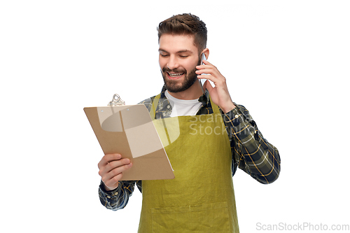 Image of male gardener with clipboard calling on smartphone
