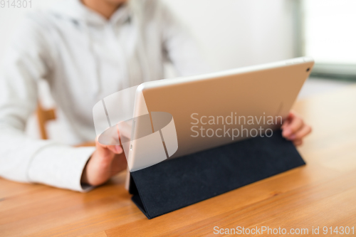 Image of Woman using tablet computer at home