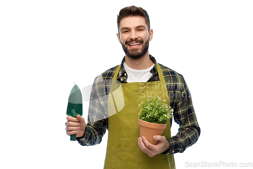 Image of happy gardener or farmer with trowel and flower