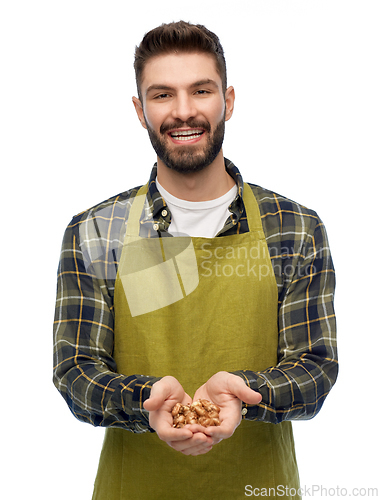 Image of happy young male gardener or farmer with bulbs