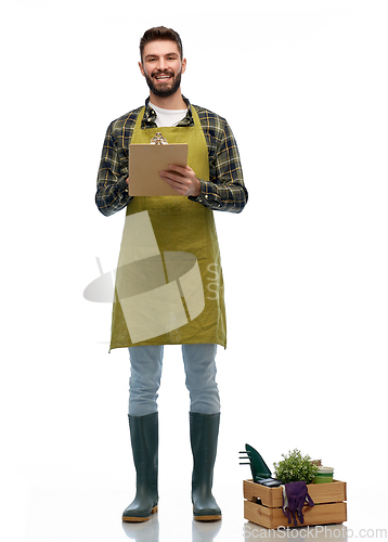 Image of happy gardener with clipboard with garden tools