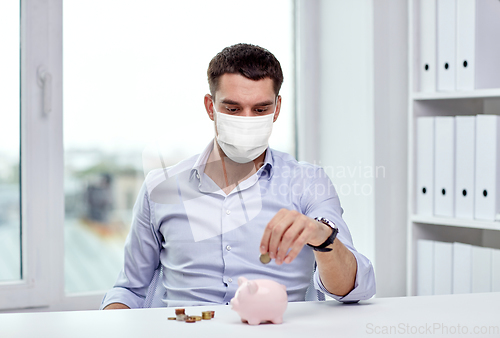 Image of businessman in mask with piggy bank and money