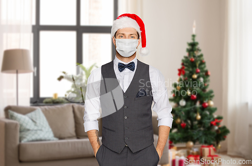 Image of man in santa hat and medical mask on christmas
