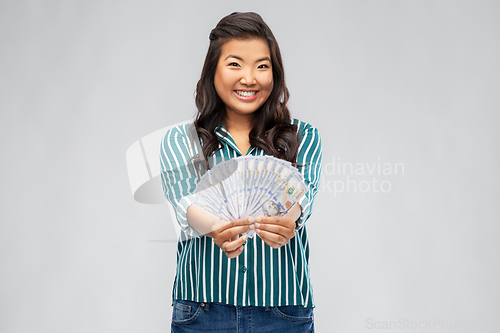 Image of asian woman with hundred dollar money banknotes