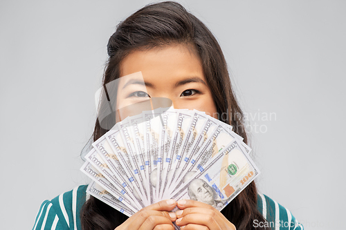 Image of asian woman with hundred dollar money banknotes