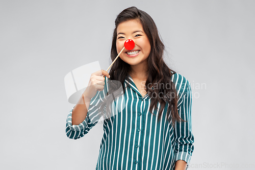 Image of happy asian woman with red clown nose