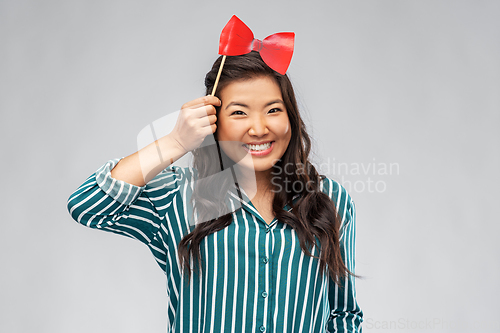 Image of happy asian woman with red party bow