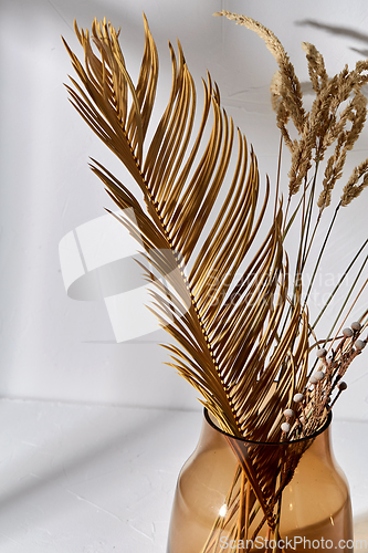 Image of decorative dried flowers in brown glass vase