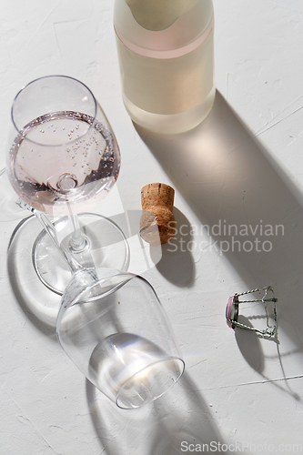 Image of wine glasses and champagne bottle dropping shadows