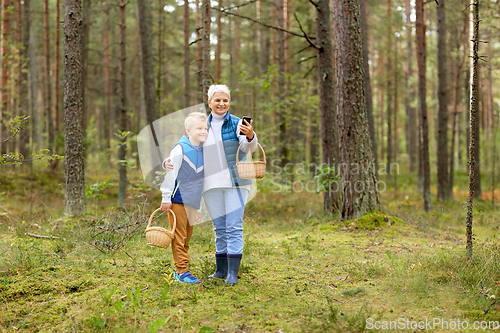 Image of grandmother and grandson with baskets take selfie