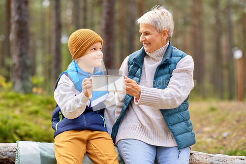 Image of grandmother with grandson drinking tea in forest