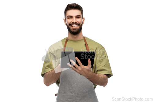 Image of smiling waiter in apron with tablet pc computer