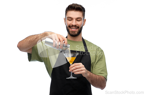 Image of happy barman with shaker and glass preparing drink