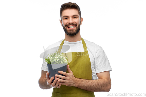 Image of happy smiling male gardener with flower in pot