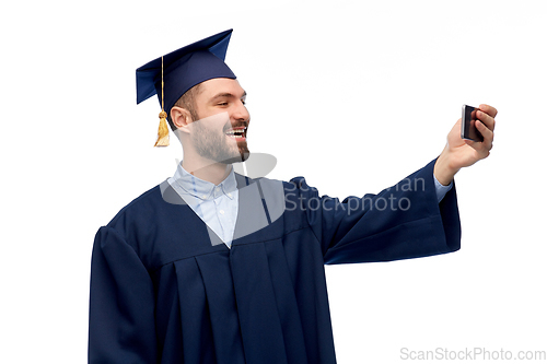 Image of male graduate student with smartphone takes selfie