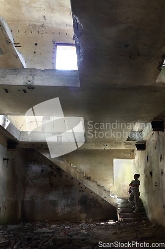 Image of A woman looking at the ruins of a building