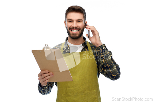 Image of male gardener with clipboard calling on smartphone