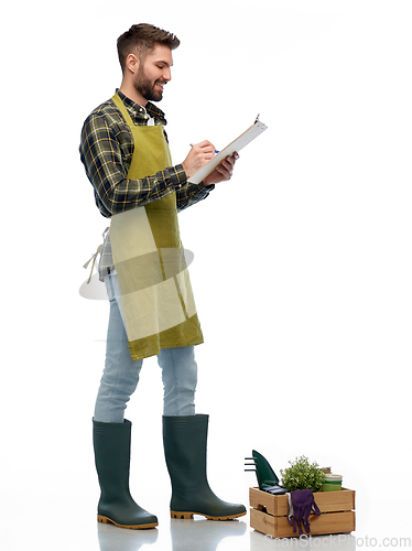 Image of happy gardener with clipboard with garden tools