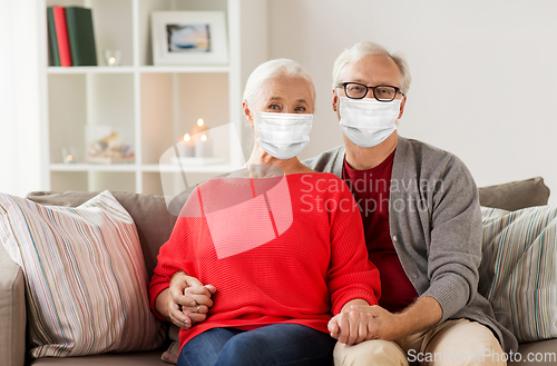 Image of senior couple in masks on christmas at home