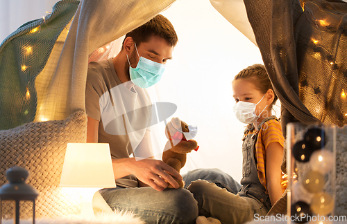 Image of happy family playing with toy in kids tent at home